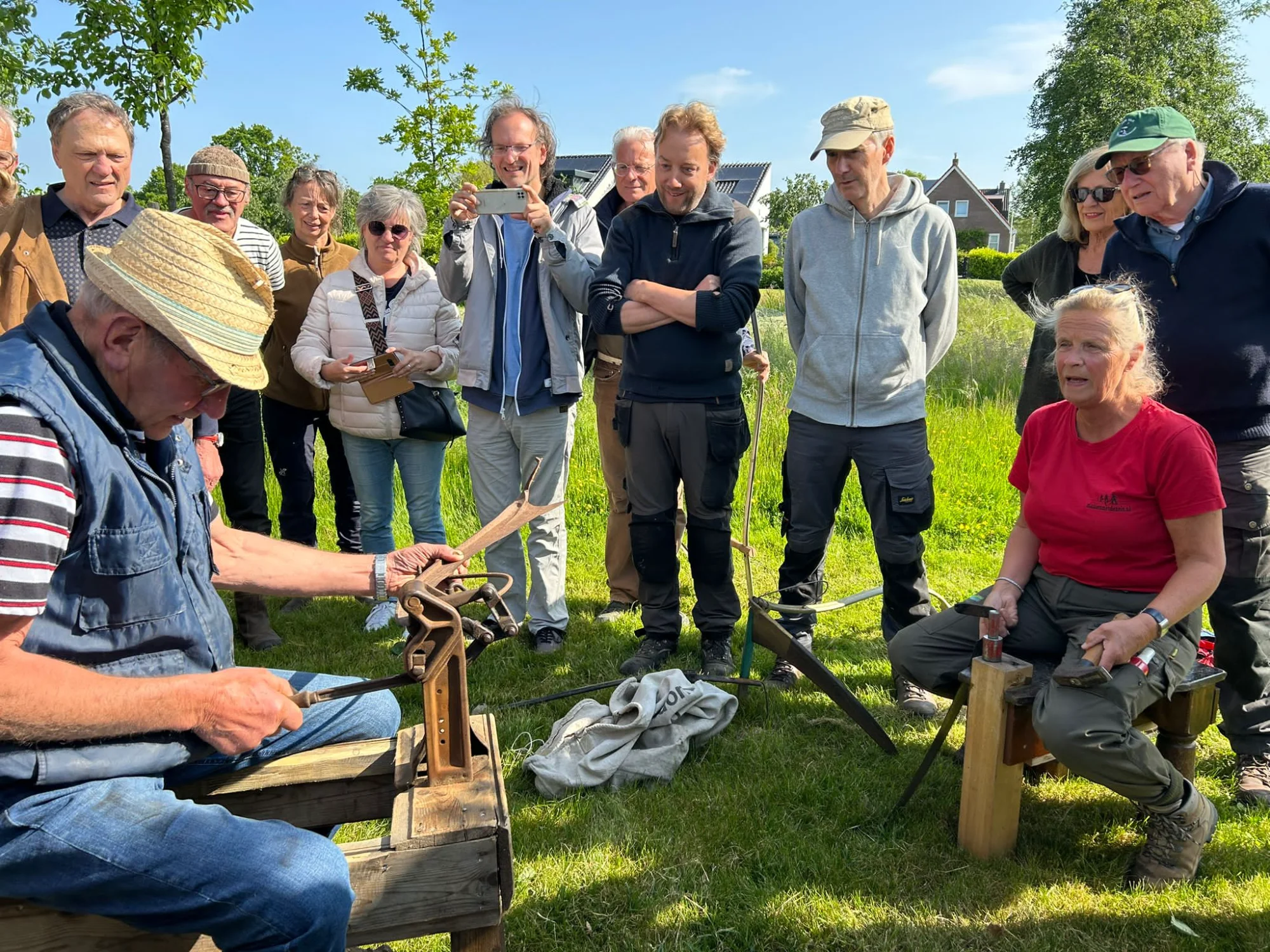 De smid leert zeisen slijpen